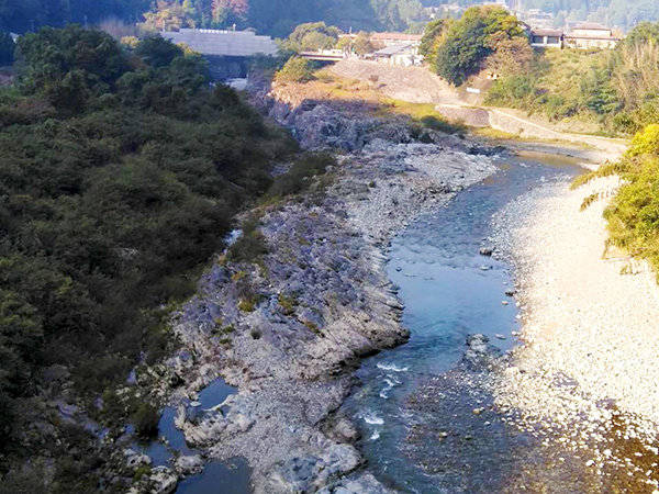 柴橋付近より俯瞰で撮影された、吉野川の岩場および河川敷の風景写真。写真奥に宮滝大橋の橋梁も確認できる