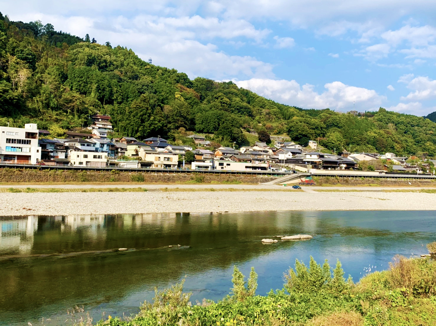 吉野川南岸より撮影された、リバーフィールドよしのの河川敷と吉野町上市の街並みの写真