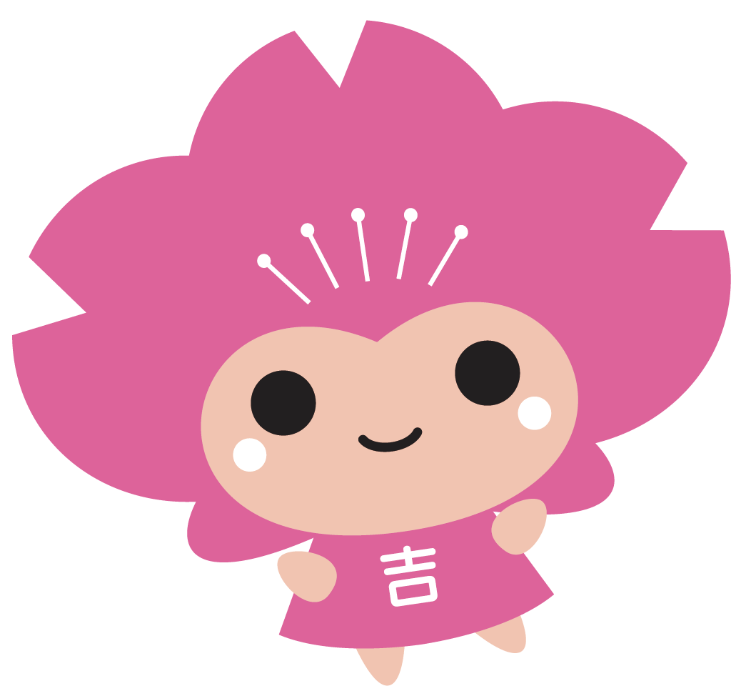 左に傾いた胸に「吉」の文字が書かれたピンク色のキャラクター、ピンクルのイラスト