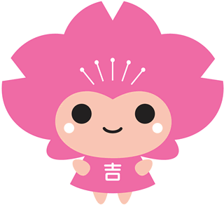 ピンクをバックに白字で「吉」という文字が入った体と、ピンクの花のような形をした頭をしているキャラクターのイラスト