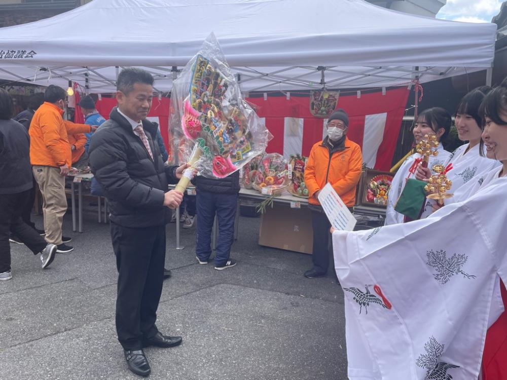 上市蛭子神社初市の様子。町長が熊手を持って巫女に祈願されている。