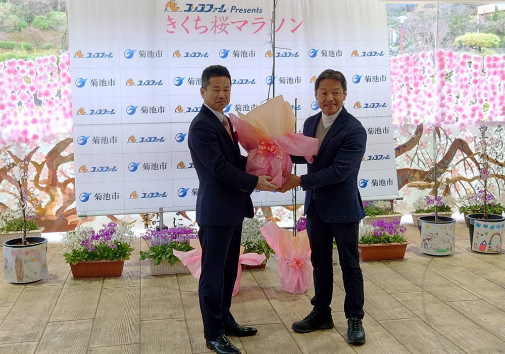 熊本県菊池市に桜を贈呈した写真。左は中井町長。右は熊本県菊池市長。桜の苗を渡している様子。