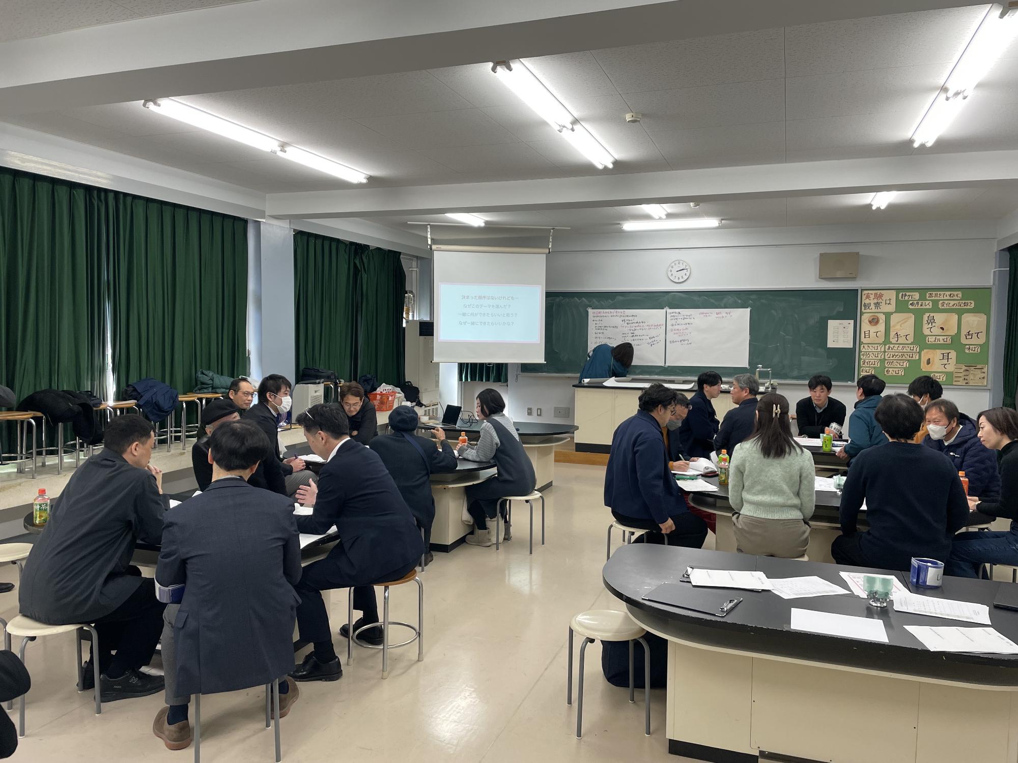 旧吉野小学校跡地で行われた旧吉小みんなで考える会の様子。机に4人~6人ずつ集まり、4組が会議を行っている。