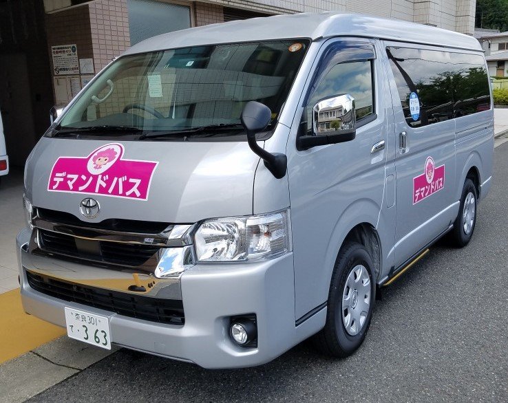 フロントと左側面に「デマンドバス」と書かれたハイエースの写真