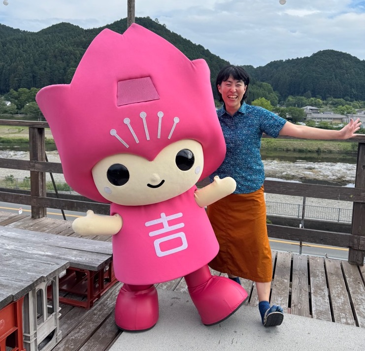 吉野関係案内人の紹介写真。吉野町公式マスコットキャラクターピンクルと笑顔で写っている。