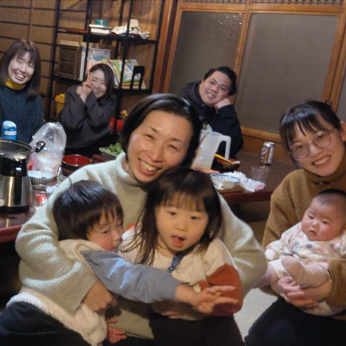 仲の良い友人と集まる米須さん家族。赤ちゃんも含めて8人が笑顔で写っている。