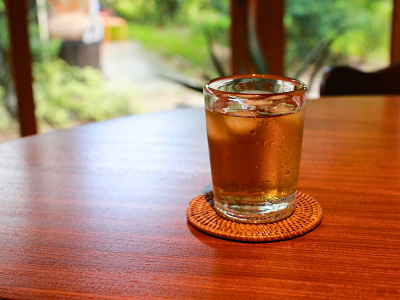 机の上に置いてあるコップ。コップの中身はお茶。室内気温の温度差でコップは汗をかいている。