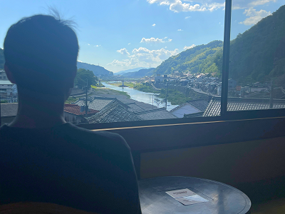 室内から外を眺める男性。外では天気の良い吉野川の全景が一望できる。