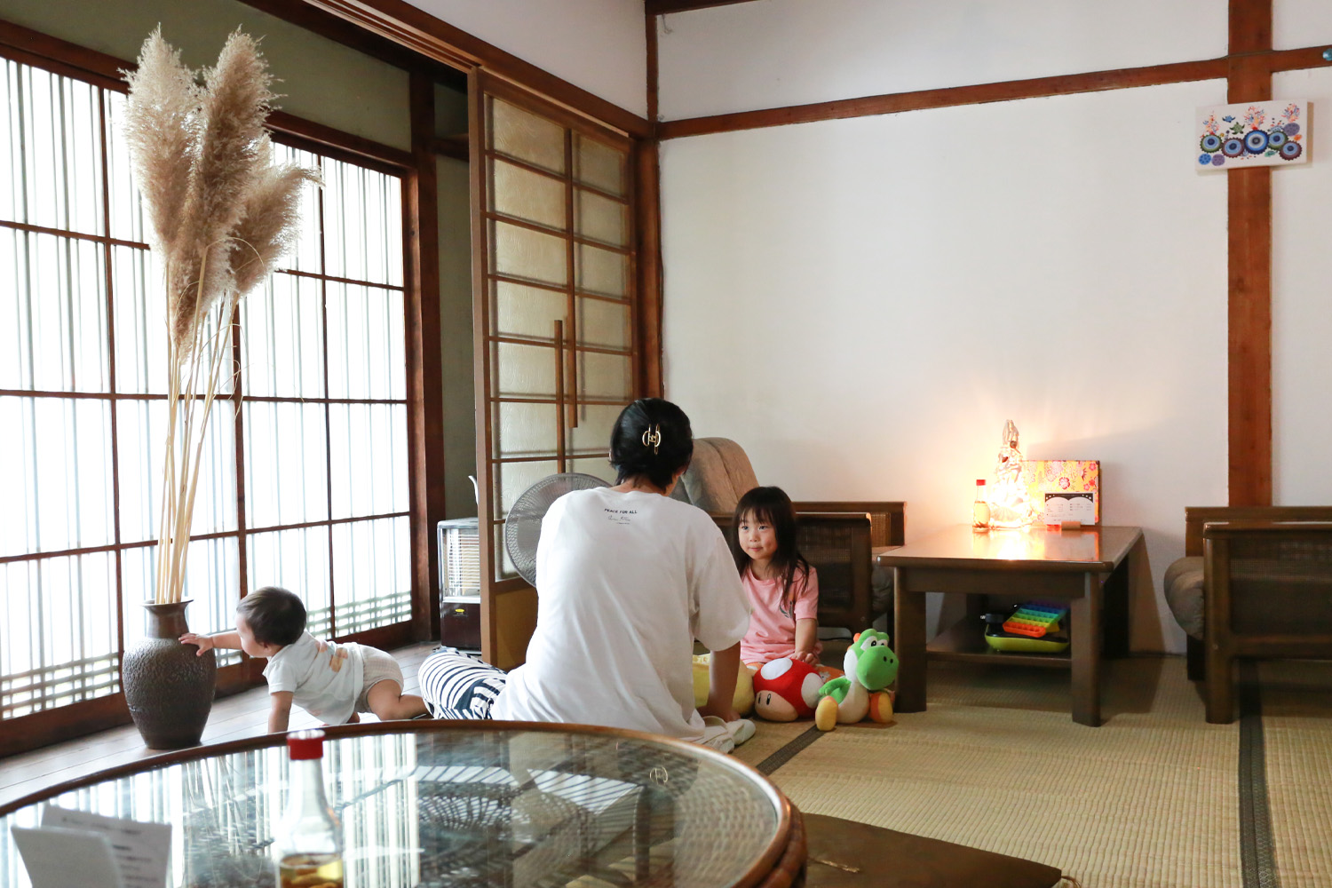 母と未就学児2名が部屋で話をしている様子。