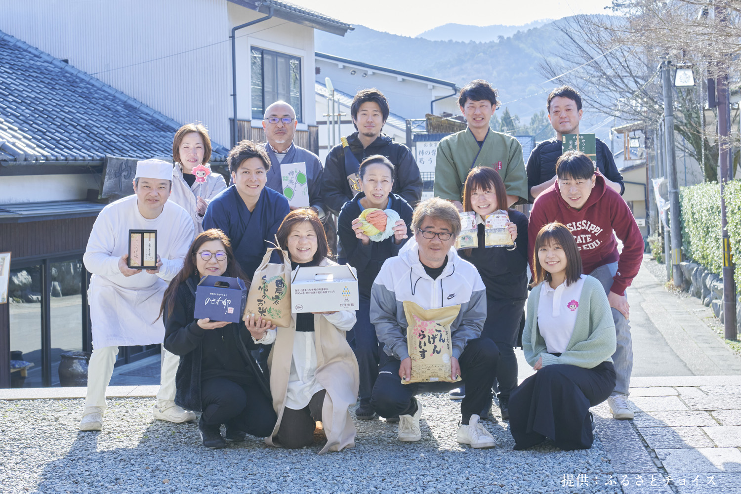 ふるさと返礼品を持って笑顔の吉野町民12名と職員担当者2名。画像提供はふるさとチョイス。