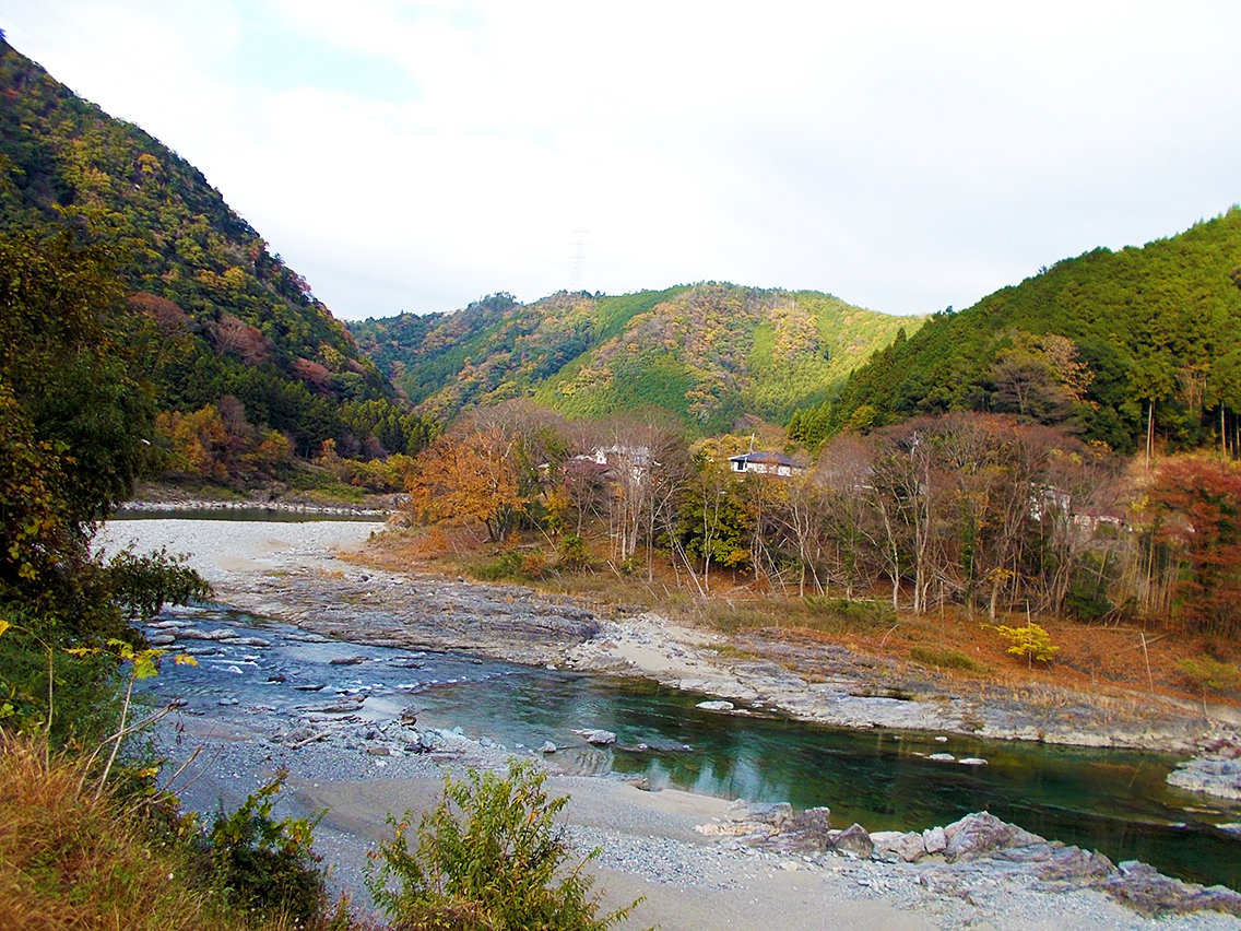 吉野川南岸より撮影された、竹谷駐車場付近の岩場と吉野町矢治の集落の遠景写真