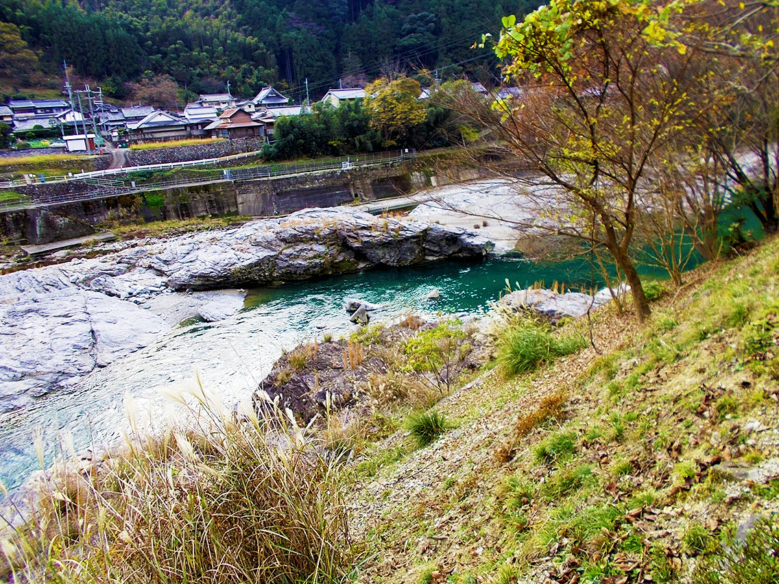 吉野川北岸より撮影された、竹谷駐車場付近の岩場と吉野町樫尾の集落の風景写真