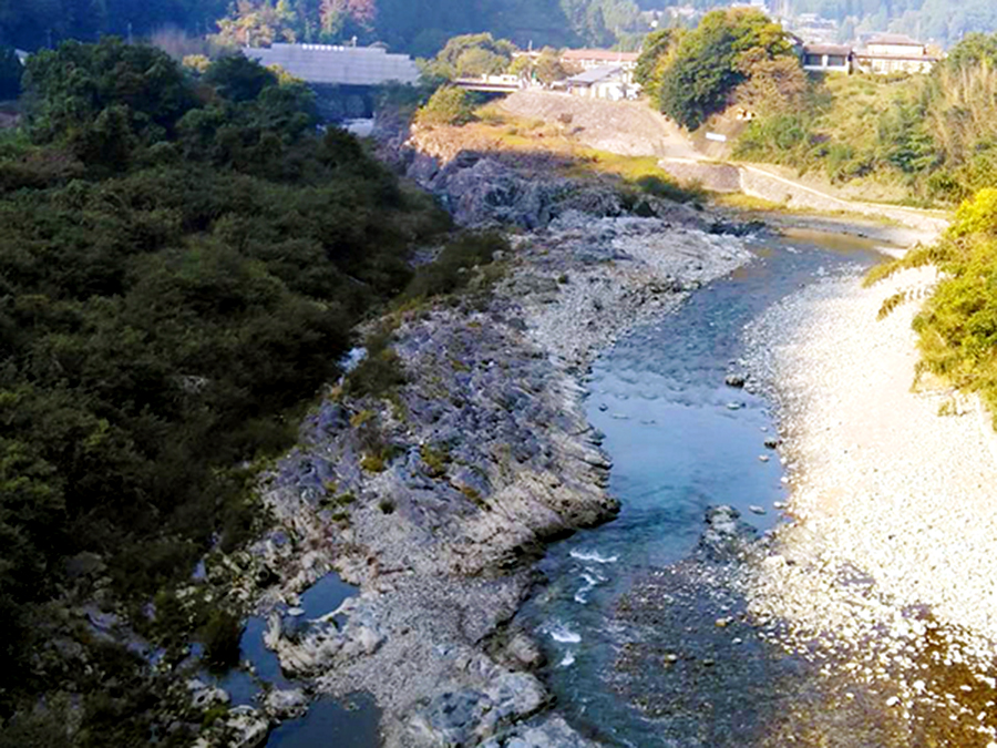 柴橋付近より俯瞰で撮影された、吉野川の岩場および河川敷の風景写真。写真奥に宮滝大橋の橋梁も確認できる