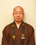 袈裟を着た安田 明城さんの写真