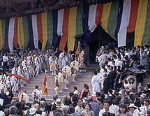 多くの人たちに見守られながら寺の階段を上る僧侶や山伏の写真
