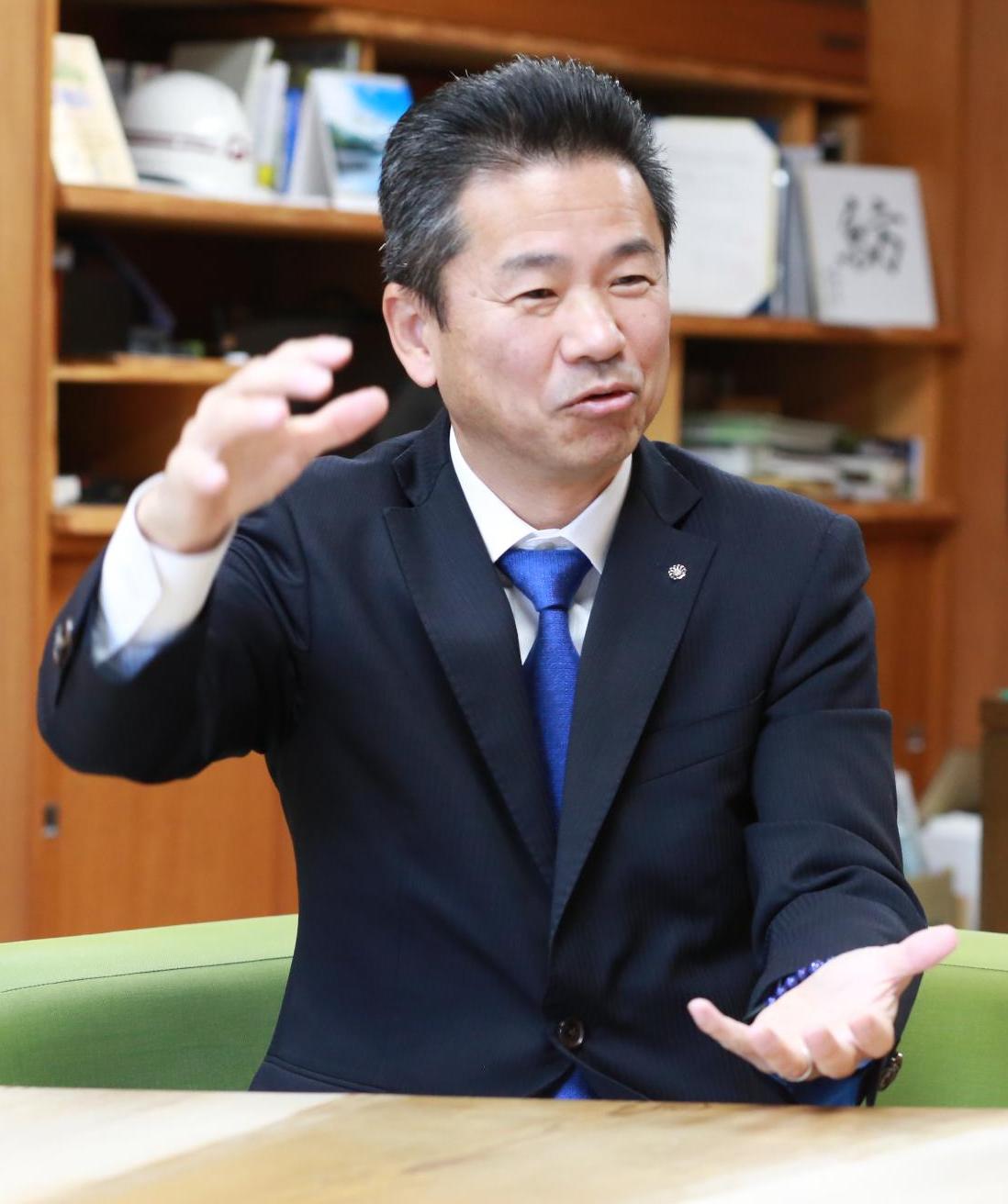 紺色のスーツにブルーのネクタイをした中井町長が説明している様子