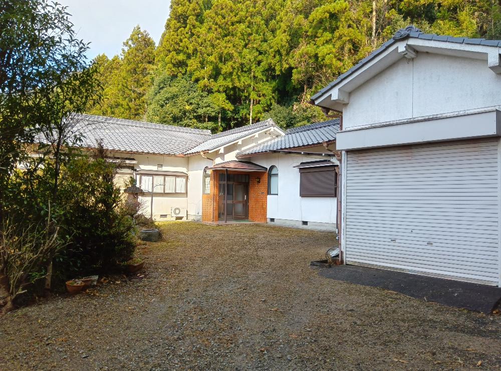 外装は白い壁、家の前は砂利がひいてある。