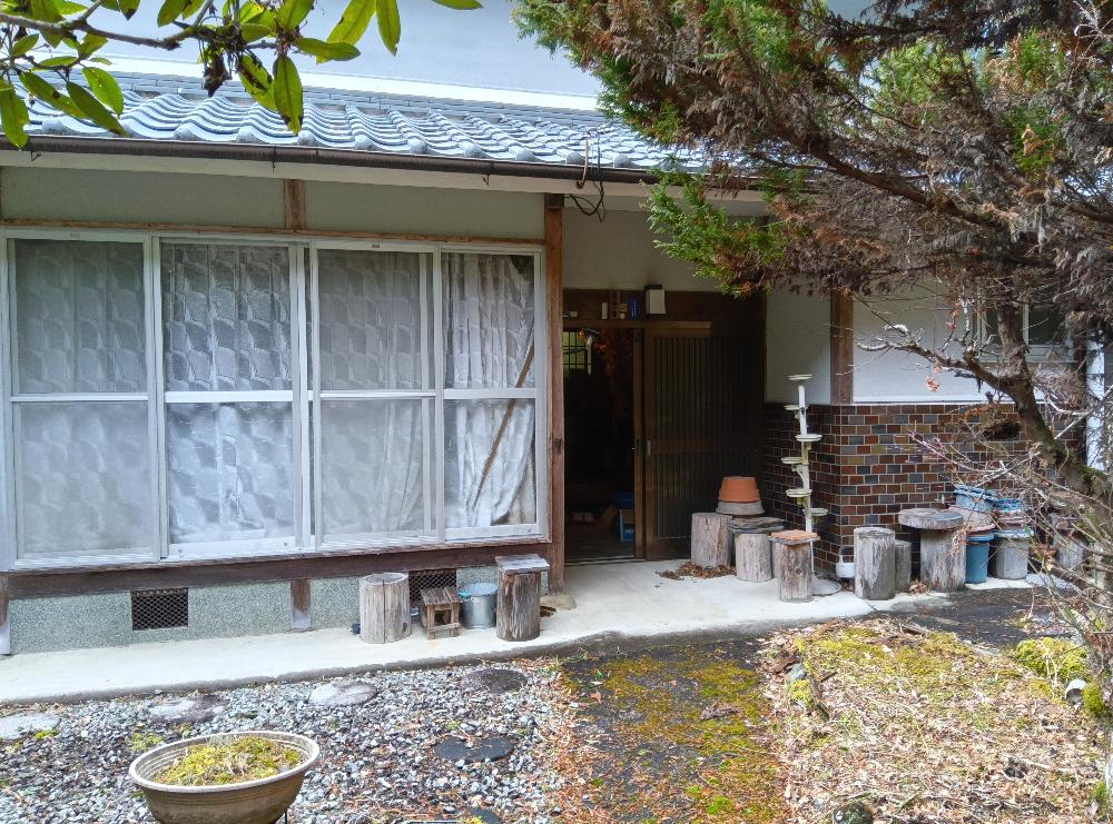外観はねずみ色の壁で引き戸の玄関の横に縁側がある