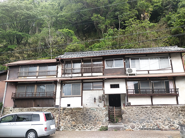 石垣の上に立つ木造2階建ての建物の写真