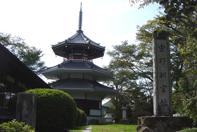 「吉野町宮址」と彫られた石柱と三重塔の写真
